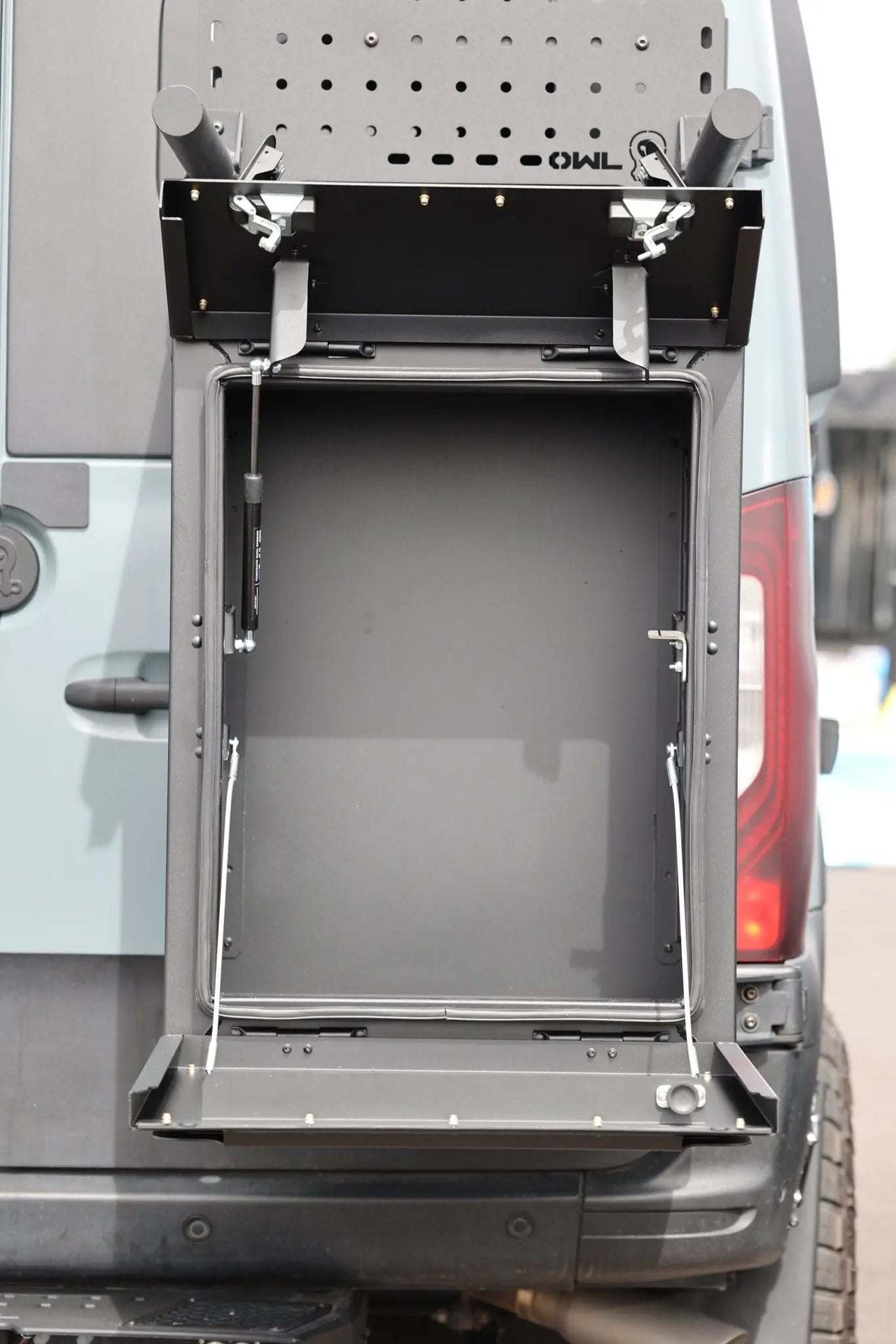 Open box showing Owl Monster 30 van storage box installed on back of van with lid open