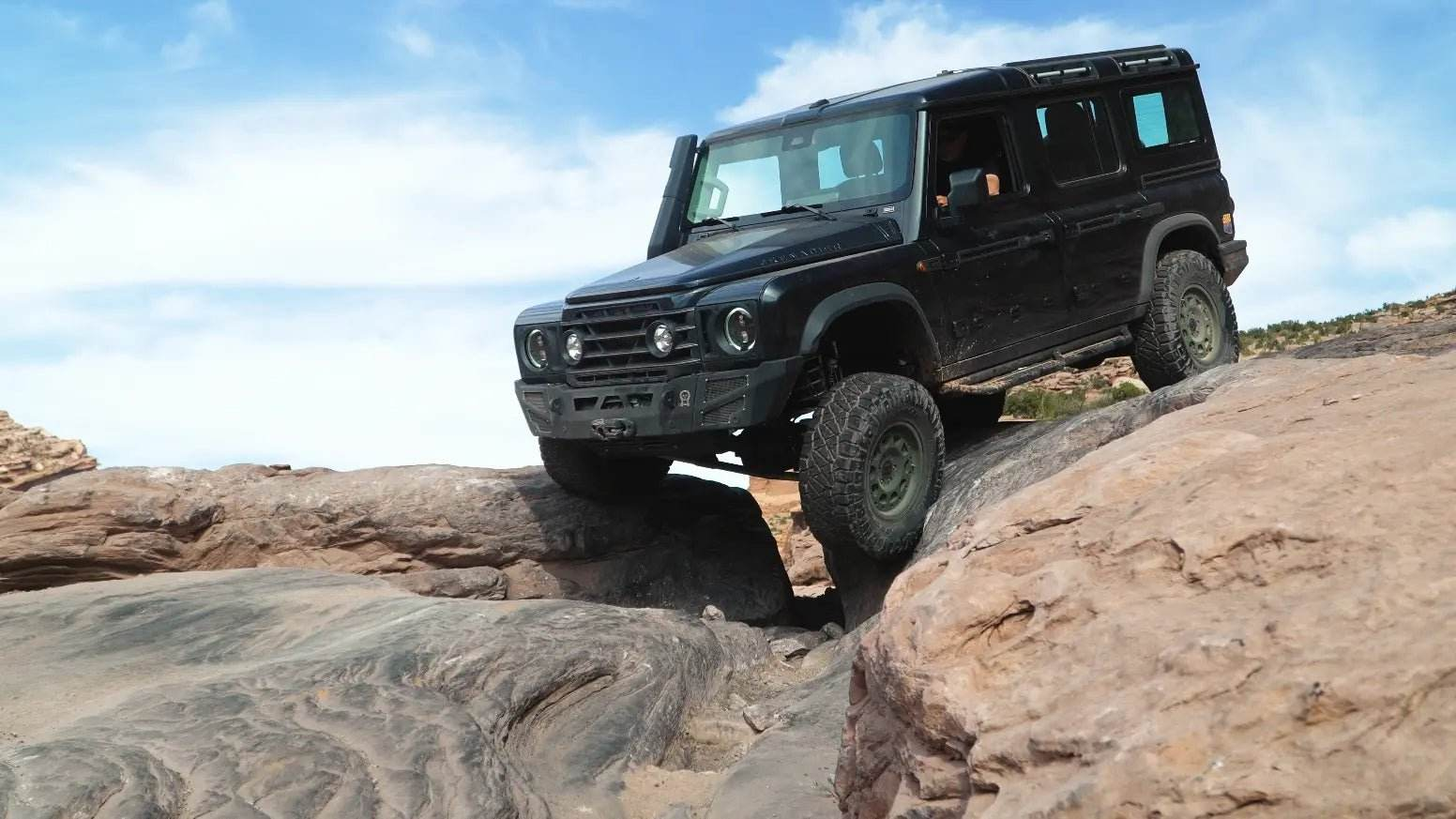 Grenadier Suspension - Black INEOS Grenadier off-road vehicle equipped with Owl 4" Lift TrailFlo Suspension climbing rocky terrain