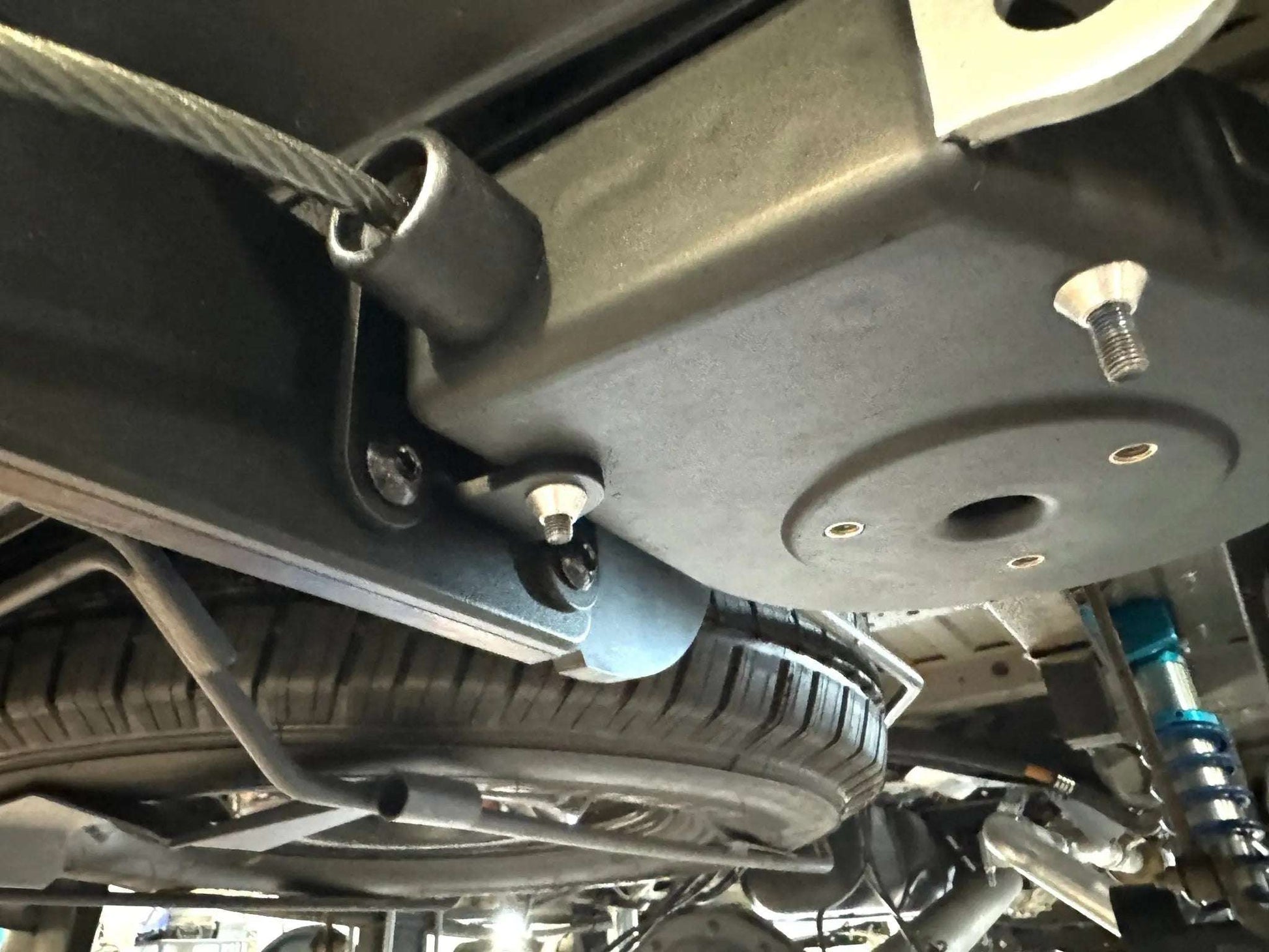 Retractable bike gear lock under Sprinter for adventure and durability.