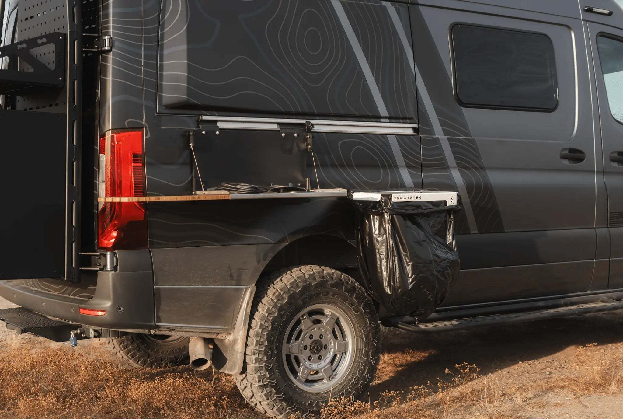 Trail Trash Magnetic Overlanding Trash Holder on a rugged outdoor vehicle for off-grid setups.