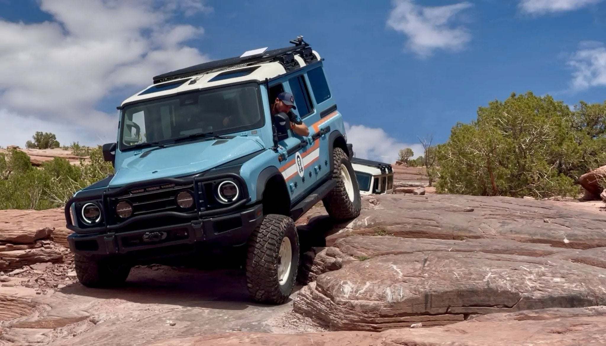 INEOS Grenadier with power retractable rock slider side steps navigating rocky terrain.